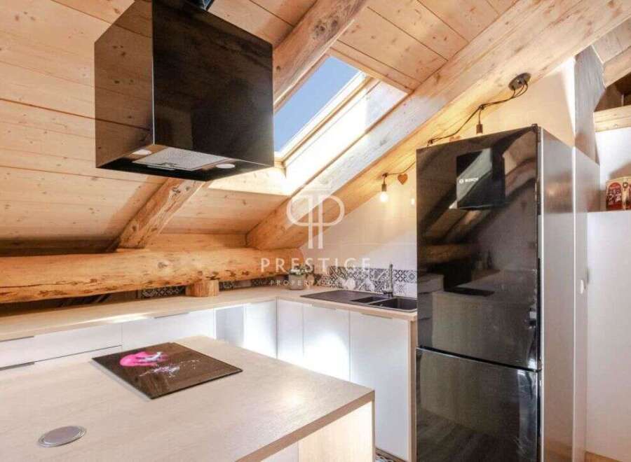 Discover this stunning property featuring a modern kitchen with sleek black appliances and a unique skylight.