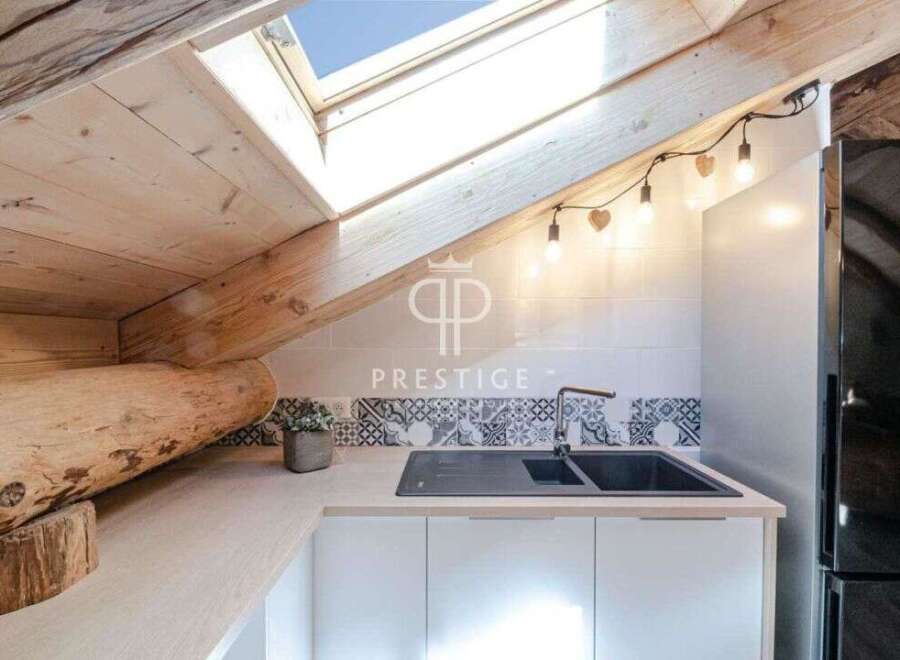 Discover the charm of this unique property, featuring a cozy kitchen with a skylight and wooden accents.