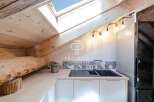 Discover the charm of this unique property, featuring a cozy kitchen with a skylight and wooden accents.