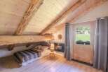 Discover the charm of this cozy bedroom with its rustic wooden beams and inviting ambiance.