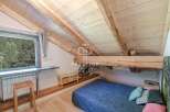 Discover the charm of this unique property, featuring a cozy bedroom with a stunning wooden ceiling and exposed beams.