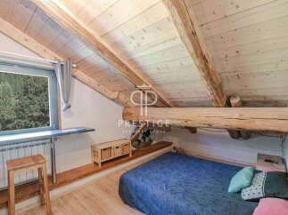Discover the charm of this unique property, featuring a cozy bedroom with a stunning wooden ceiling and exposed beams.
