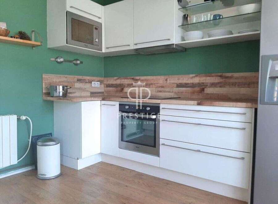 Modern kitchen with sleek white cabinetry and stainless steel appliances.