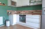 Modern kitchen with sleek white cabinetry and stainless steel appliances.