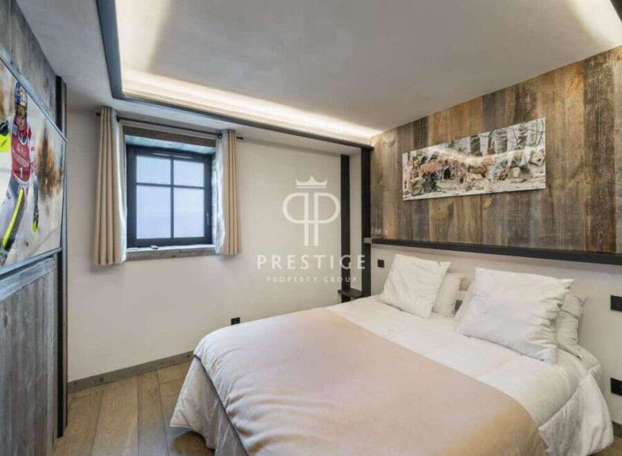 Experience luxury in this stunning bedroom featuring a cozy bed and elegant wooden accents.