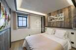 Experience luxury in this stunning bedroom featuring a cozy bed and elegant wooden accents.