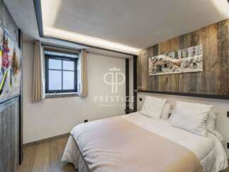 Experience luxury in this stunning bedroom featuring a cozy bed and elegant wooden accents.