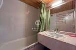 This bathroom features a sleek design with a modern sink and a spacious bathtub.