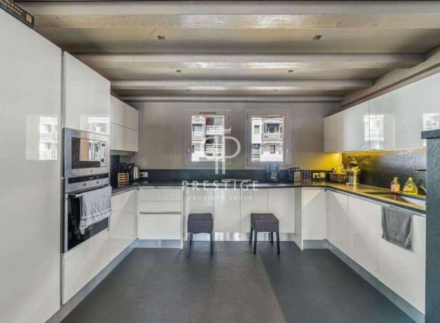 Discover a modern kitchen with sleek white cabinetry and a dark countertop, perfect for culinary enthusiasts.