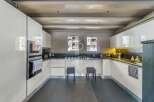 Discover a modern kitchen with sleek white cabinetry and a dark countertop, perfect for culinary enthusiasts.