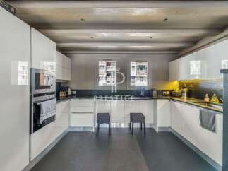 Discover a modern kitchen with sleek white cabinetry and a dark countertop, perfect for culinary enthusiasts.