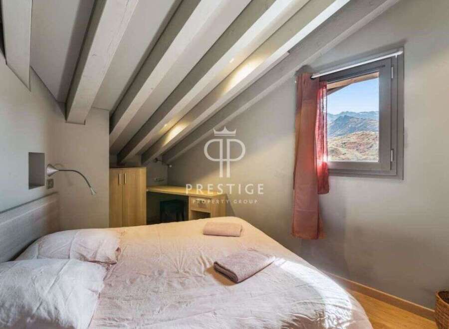 Discover the charm of this cozy bedroom, featuring a unique sloped ceiling with exposed beams.