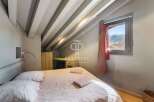 Discover the charm of this cozy bedroom, featuring a unique sloped ceiling with exposed beams.