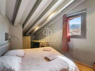 Discover the charm of this cozy bedroom, featuring a unique sloped ceiling with exposed beams.