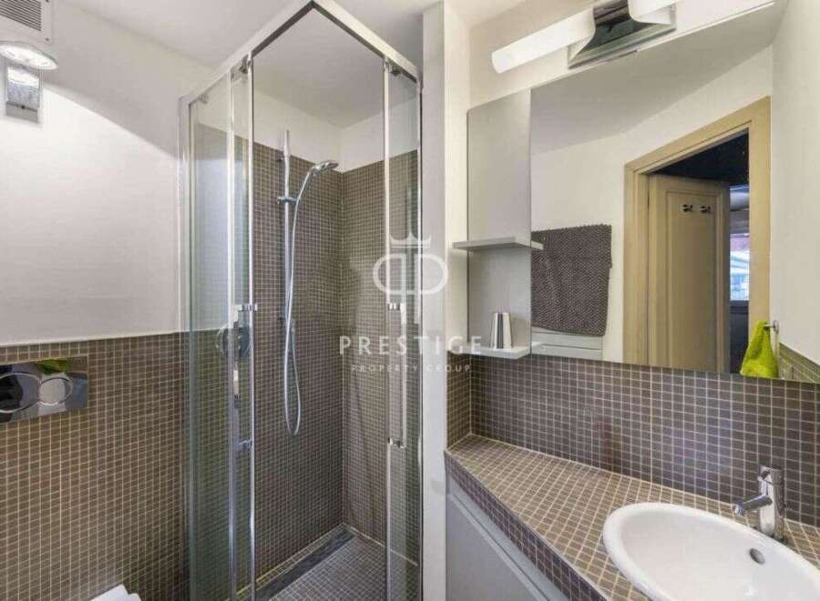 Discover this modern bathroom featuring a sleek glass shower enclosure.