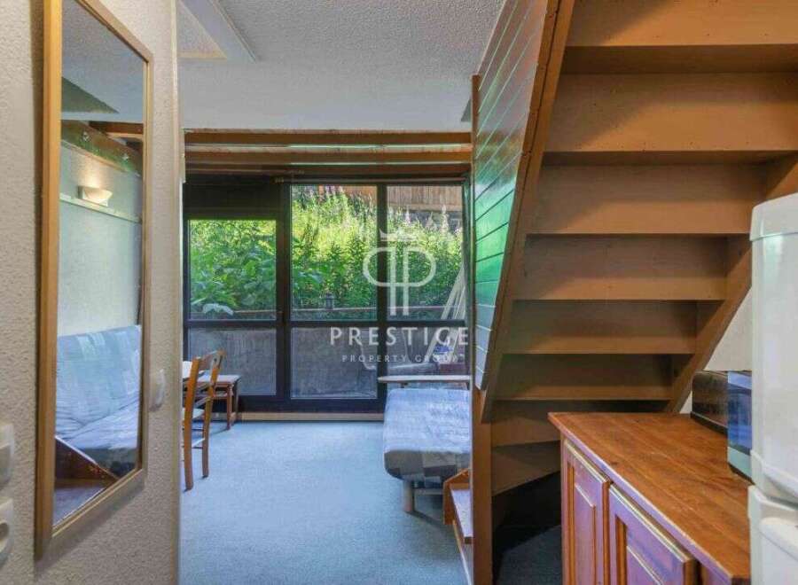 Discover a charming property with a unique layout, featuring a cozy living space and a convenient staircase.