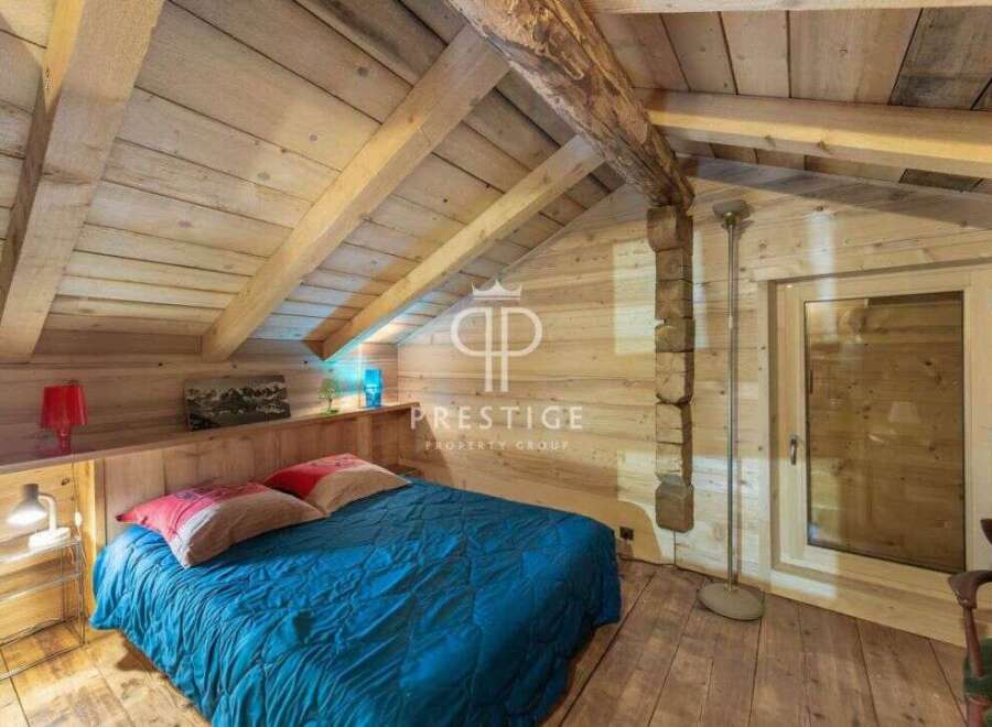 Discover the charm of this cozy bedroom, featuring a rustic wooden interior and a comfortable bed.