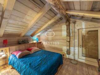 Discover the charm of this cozy bedroom, featuring a rustic wooden interior and a comfortable bed.