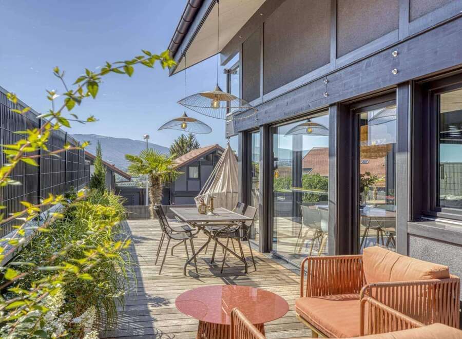 Modern deck with stylish furniture and serene mountain views.