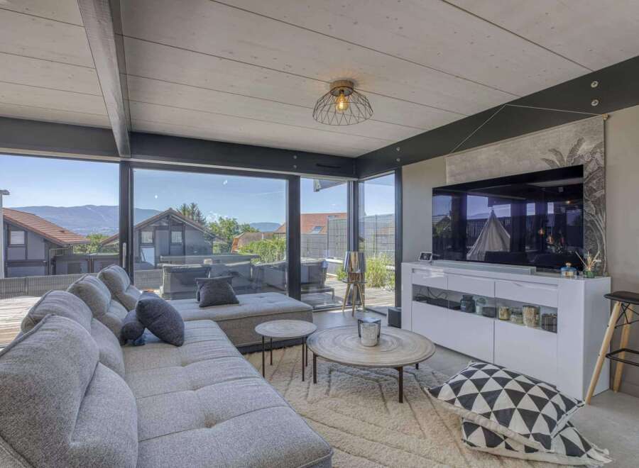 Modern living room with floor-to-ceiling windows offering scenic views.