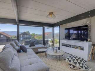 Modern living room with floor-to-ceiling windows offering scenic views.