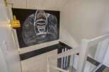 Stunning modern home featuring a dramatic gorilla painting as a statement piece above the staircase.