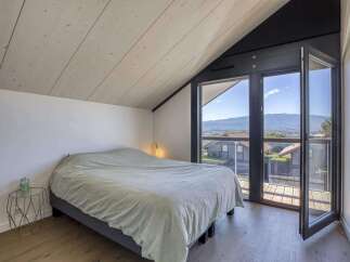 Wake up to breathtaking mountain views from this bedroom with floor-to-ceiling windows and a private balcony.