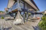 Stunning modern home with spacious deck and outdoor seating area, perfect for entertaining.