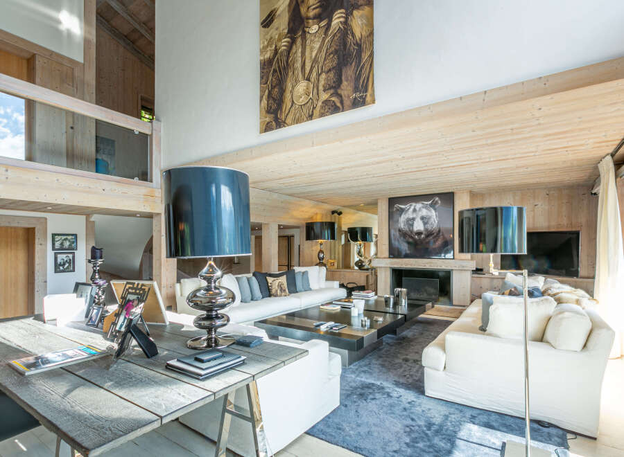 This stunning chalet boasts a spacious open-plan living area with high ceilings and large windows, creating a bright and airy atmosphere.