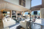 Luxurious chalet living room with floor-to-ceiling windows offering breathtaking mountain views.