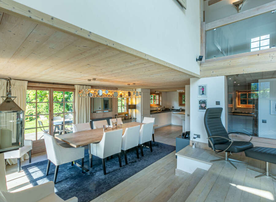 This stunning chalet boasts a spacious open-plan living area with a large dining table perfect for family gatherings.