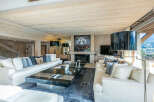 Luxurious chalet living room with floor-to-ceiling windows offering breathtaking mountain views.
