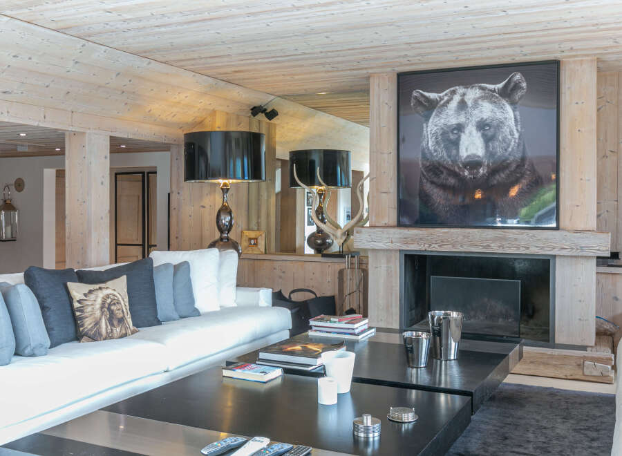 Luxurious chalet living room with a stunning fireplace and large artwork.