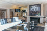 Luxurious chalet living room with a stunning fireplace and large artwork.