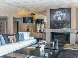 Luxurious chalet living room with a stunning fireplace and large artwork.