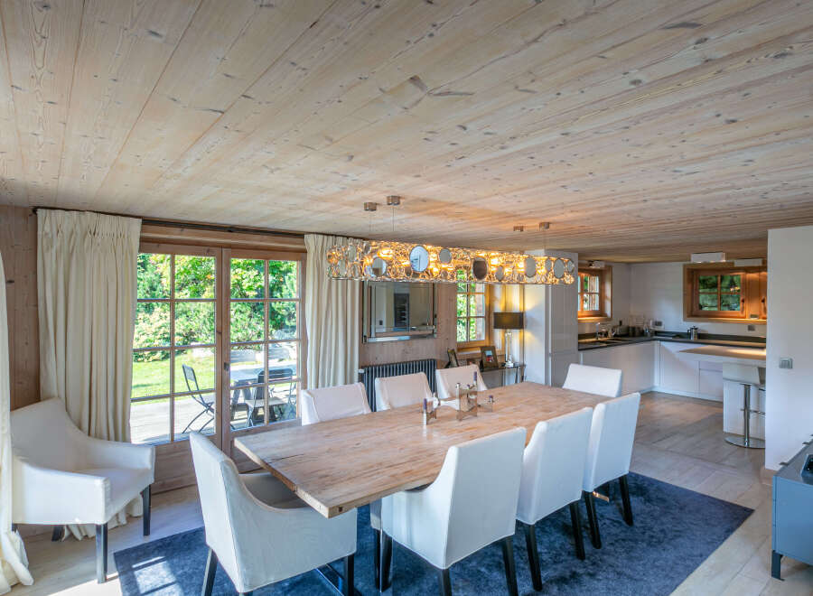 This stunning chalet boasts a spacious dining area with a large wooden table, perfect for family gatherings.