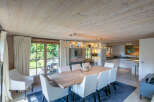 This stunning chalet boasts a spacious dining area with a large wooden table, perfect for family gatherings.