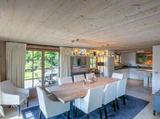 This stunning chalet boasts a spacious dining area with a large wooden table, perfect for family gatherings.