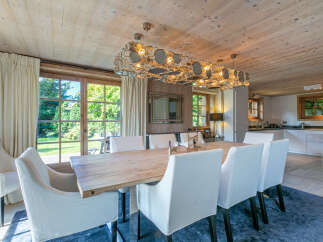 This stunning chalet boasts a spacious dining area with a large wooden table, perfect for family gatherings.