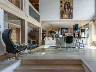 This stunning chalet boasts a spacious open-plan living area with exposed wooden beams and large windows offering breathtaking views.