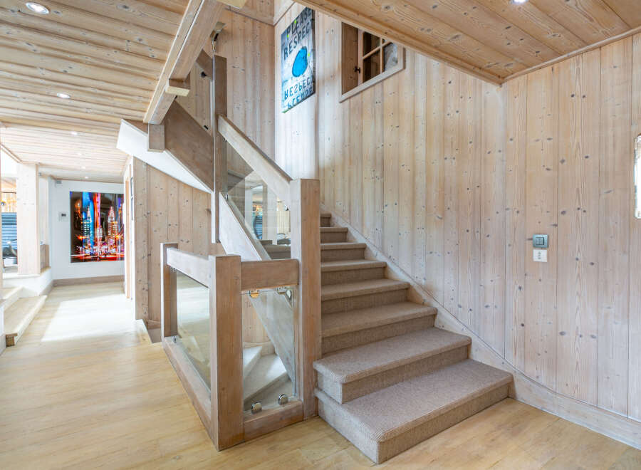 This stunning property boasts a grand staircase with a modern glass and wood railing, adding a touch of elegance to the home's interior.