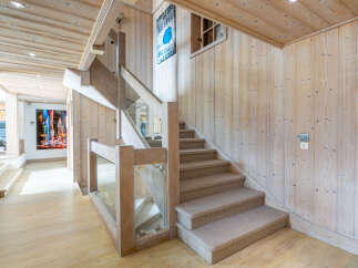 This stunning property boasts a grand staircase with a modern glass and wood railing, adding a touch of elegance to the home's interior.