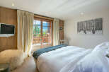 Wake up to breathtaking mountain views from this luxurious bedroom.