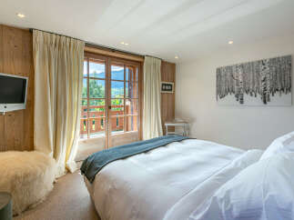 Wake up to breathtaking mountain views from this luxurious bedroom.