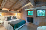 Cozy chalet bedroom with exposed wooden beams and a rustic feel.