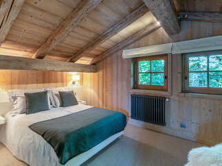 Cozy chalet bedroom with exposed wooden beams and a rustic feel.