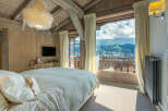 Wake up to breathtaking mountain views from this luxurious chalet bedroom.