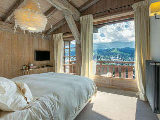 Wake up to breathtaking mountain views from this luxurious chalet bedroom.
