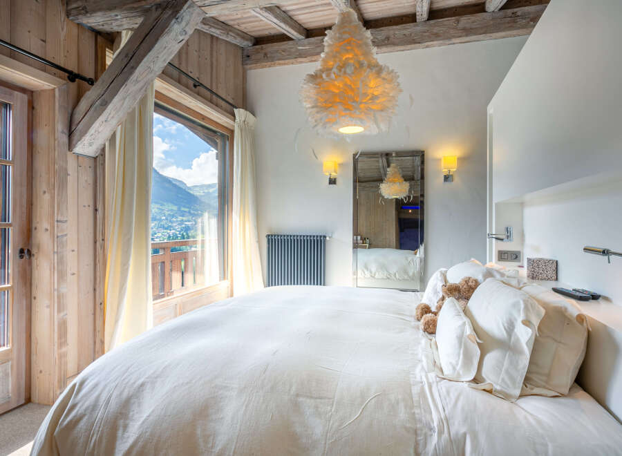 Wake up to breathtaking mountain views from this luxurious bedroom.