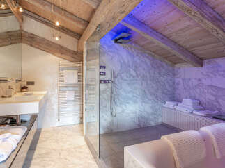 Luxurious bathroom with marble finishes and a spacious glass-enclosed shower.